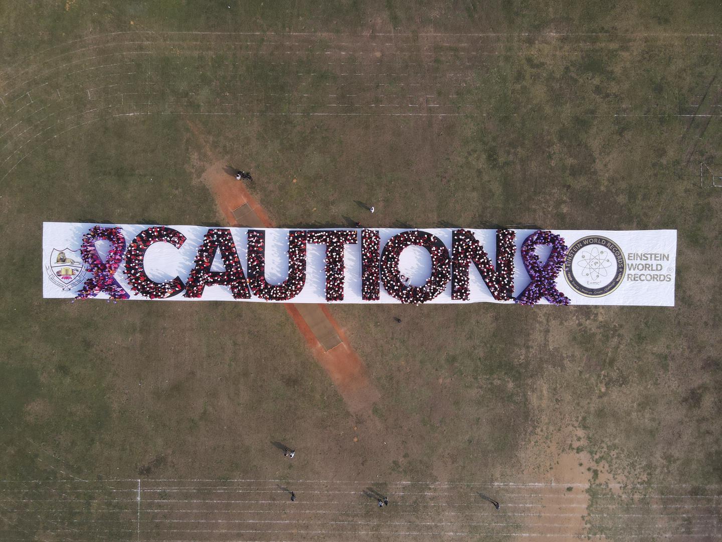 WORLD RECORD TO CREATE LARGEST HUMAN WORD “CAUTION” AND AWARENESS RIBBON BY 1500 STUDENTS