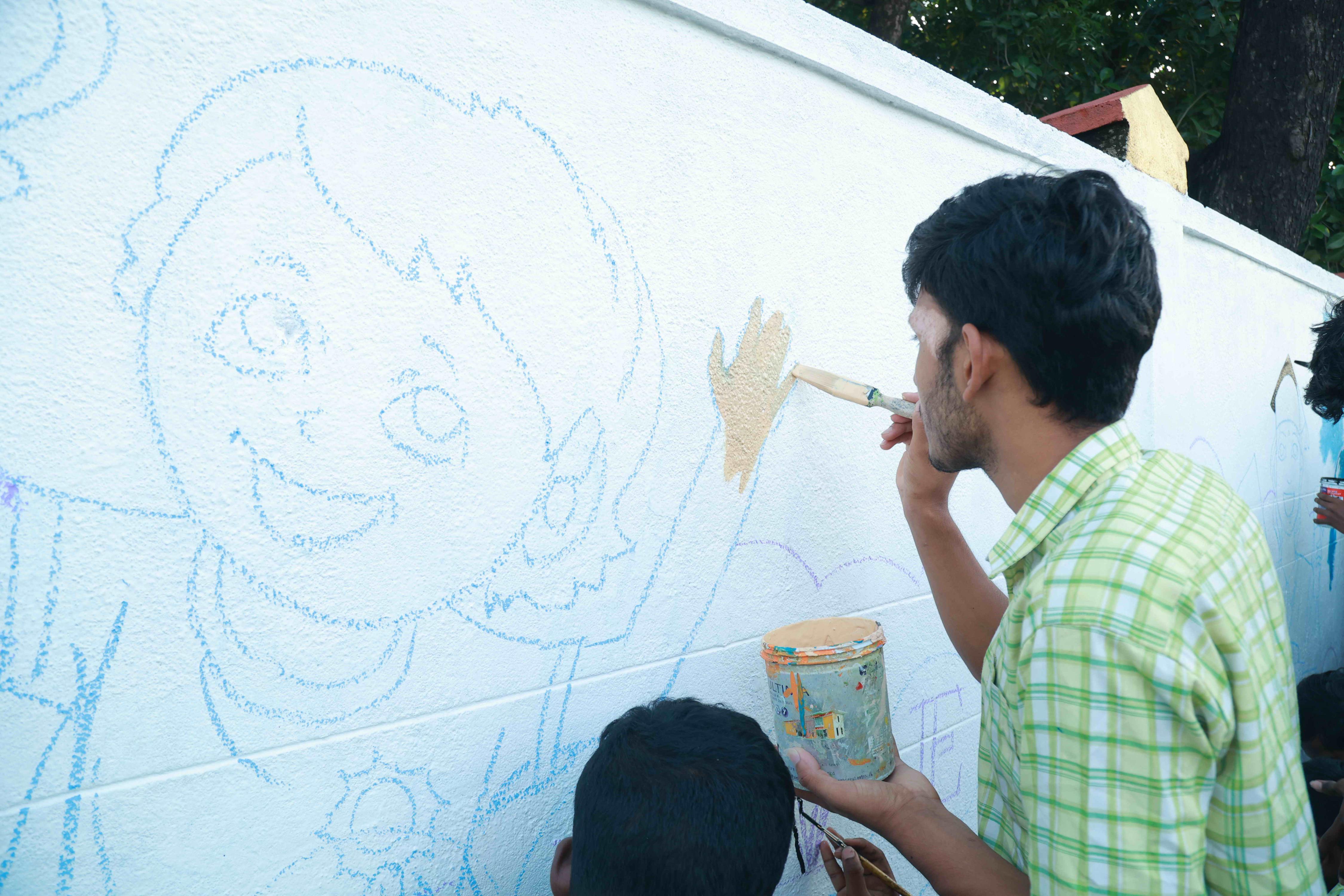 DRAW PICTURES ON A 72-INCH-HIGH AND 360-INCH-WIDE COMPOUND WALL WITHIN 2 HOURS AND 30 MINUTES BY 106 DEAF AND HARD-OF-HEARING CHILDREN.