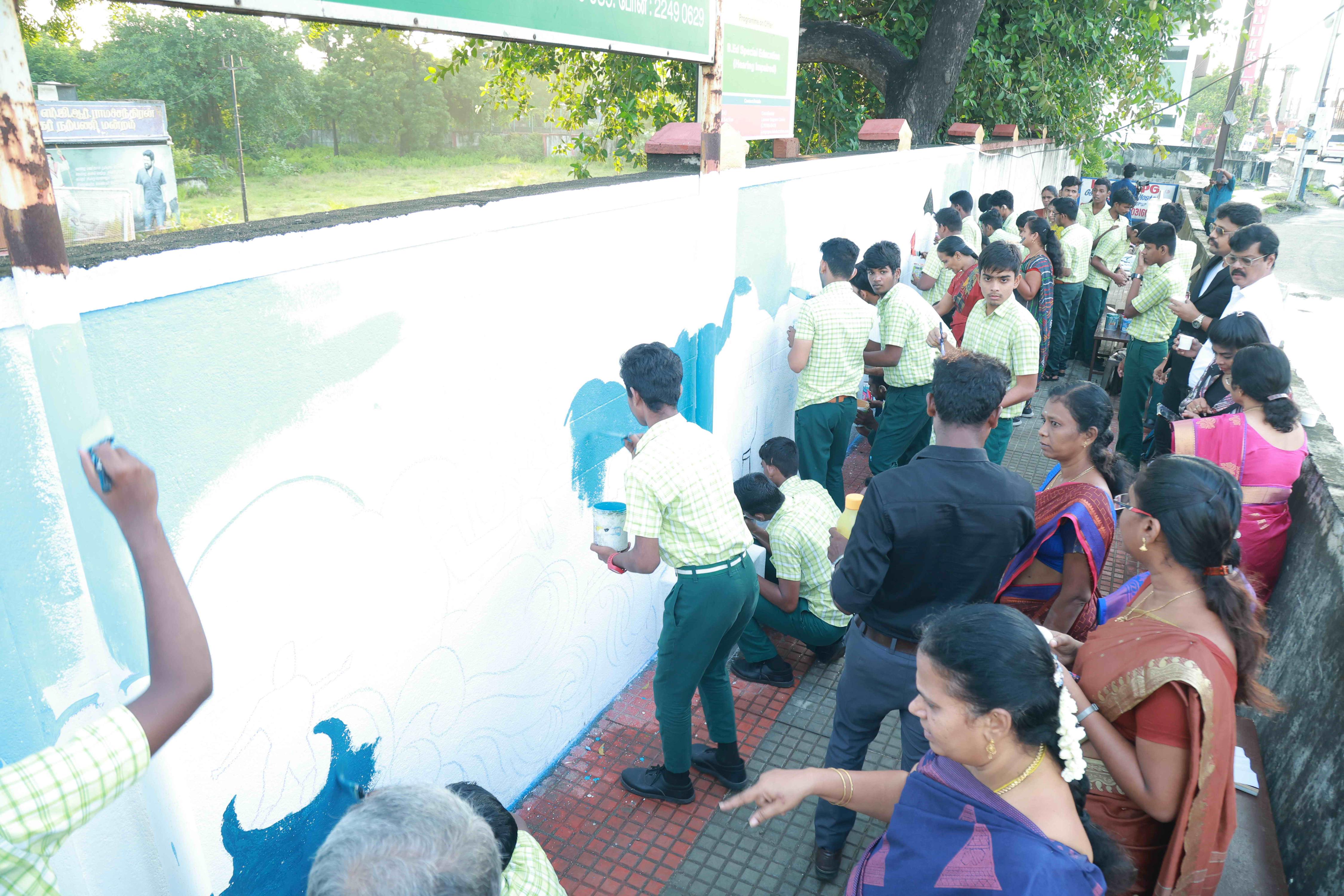 DRAW PICTURES ON A 72-INCH-HIGH AND 360-INCH-WIDE COMPOUND WALL WITHIN 2 HOURS AND 30 MINUTES BY 106 DEAF AND HARD-OF-HEARING CHILDREN.