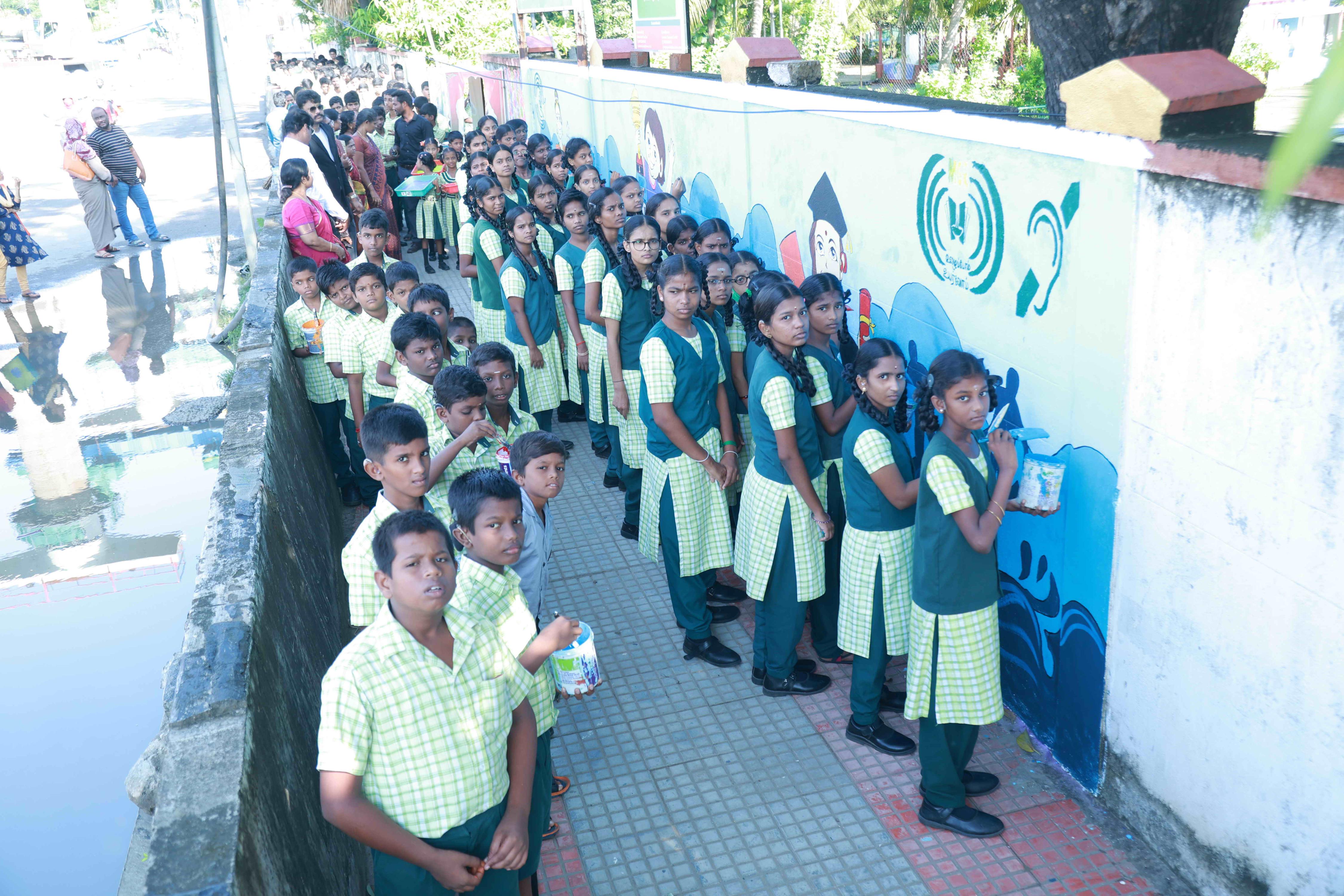 DRAW PICTURES ON A 72-INCH-HIGH AND 360-INCH-WIDE COMPOUND WALL WITHIN 2 HOURS AND 30 MINUTES BY 106 DEAF AND HARD-OF-HEARING CHILDREN.