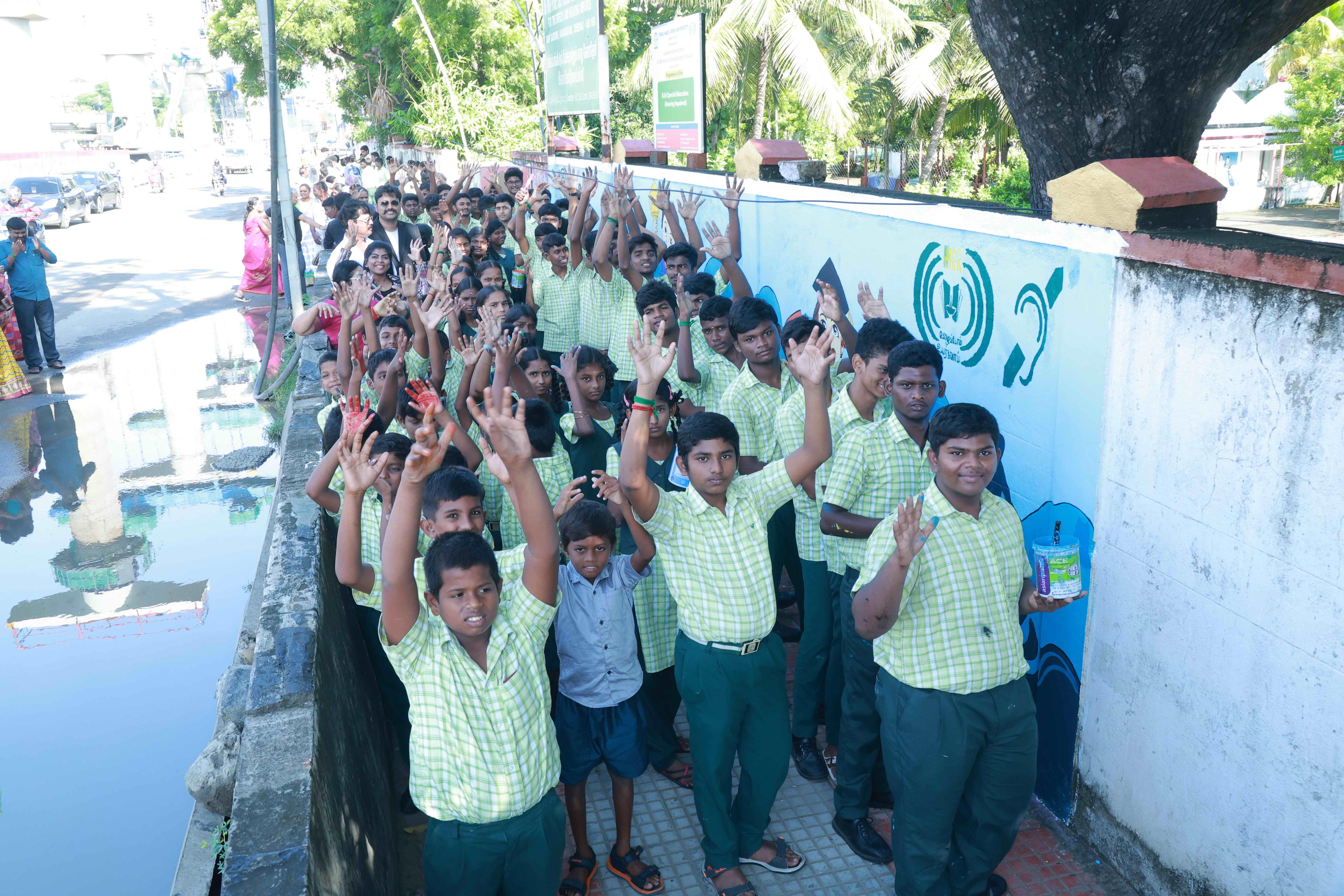 DRAW PICTURES ON A 72-INCH-HIGH AND 360-INCH-WIDE COMPOUND WALL WITHIN 2 HOURS AND 30 MINUTES BY 106 DEAF AND HARD-OF-HEARING CHILDREN.