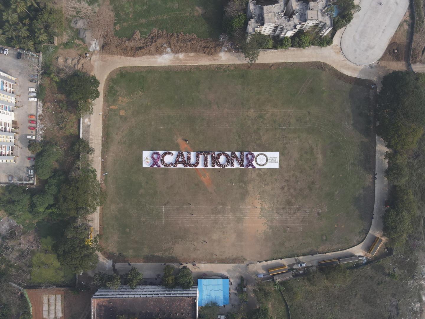 WORLD RECORD TO CREATE LARGEST HUMAN WORD “CAUTION” AND AWARENESS RIBBON BY 1500 STUDENTS